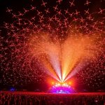 Pertunjukan drone meriah di festival musik malam hari.